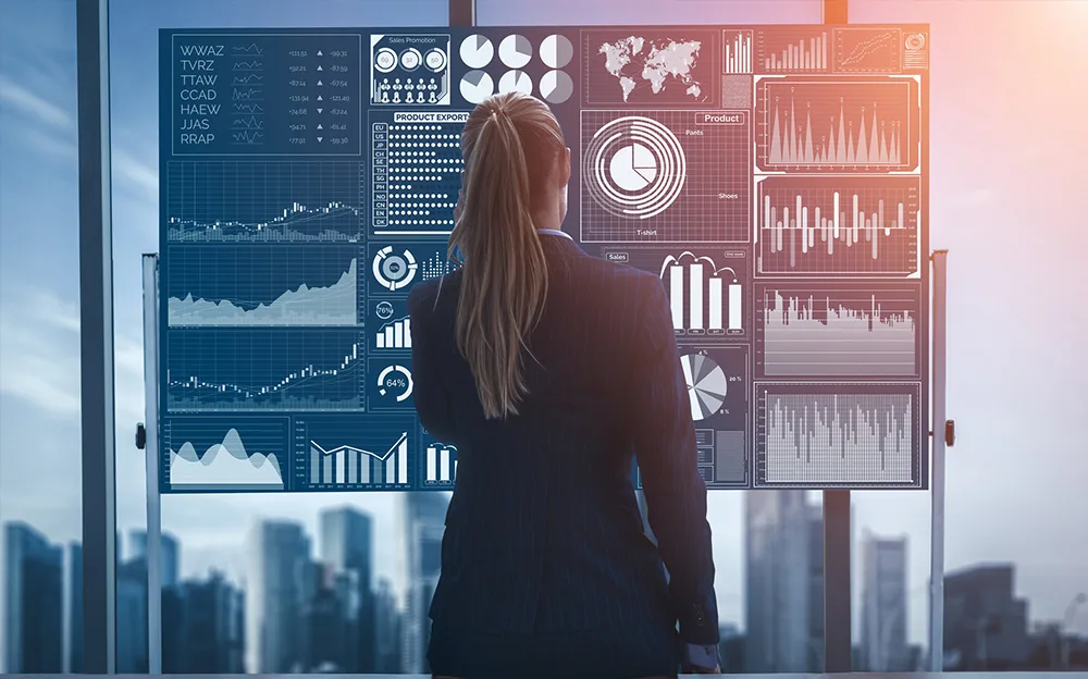 A businesswoman analyzing detailed digital data dashboards featuring graphs, charts, and statistics, set against a modern cityscape backdrop