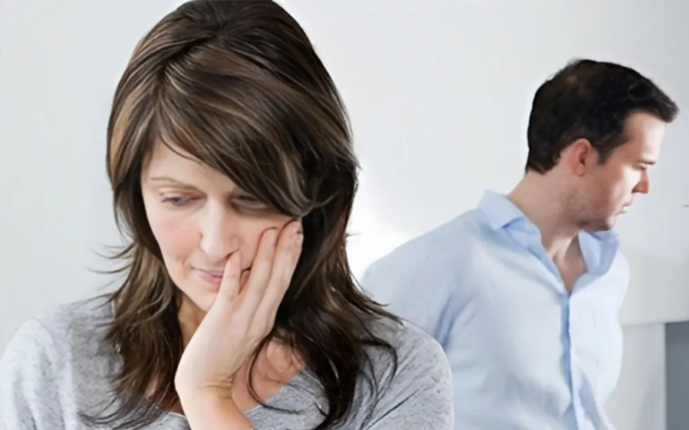 Unhappy woman looking distressed with a man standing in the background, symbolizing relationship struggles or marital issues