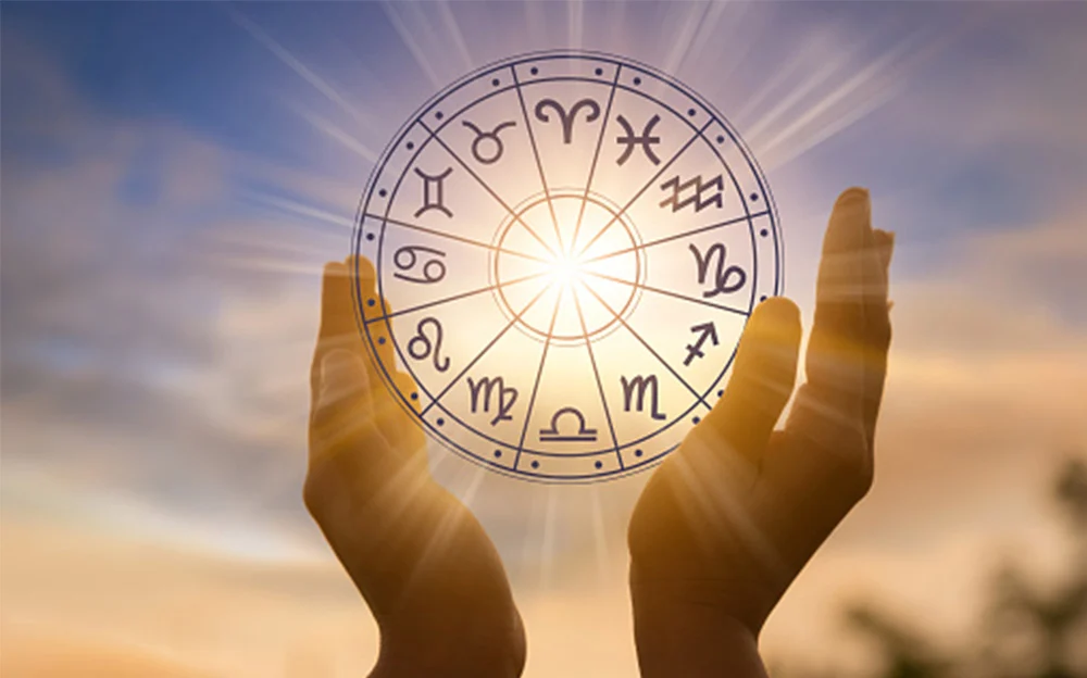 Astrology zodiac signs wheel with sunlight and hands symbolizing spiritual guidance